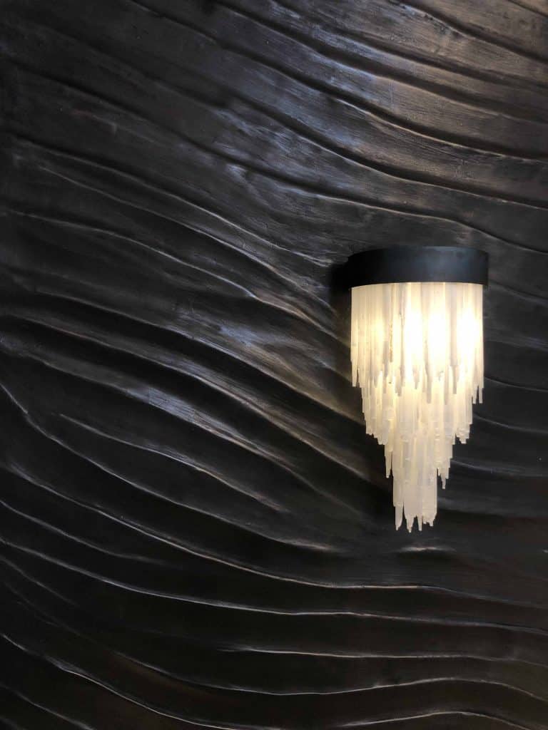 Manganese Wall with wave texture and a light on the wall